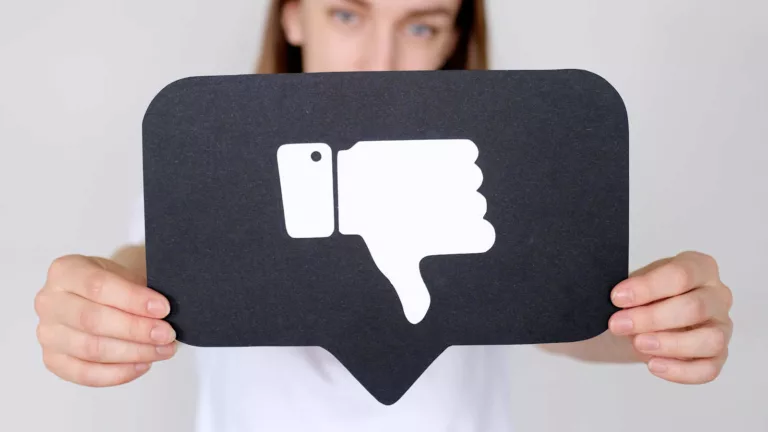 Woman holding thumbs down symbol