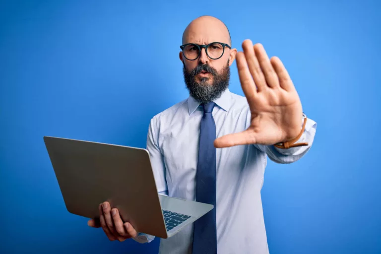 man warning of chrome extension risk holding laptop