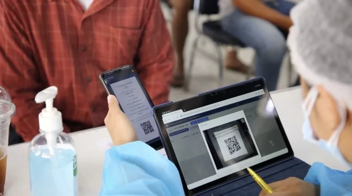 A health worker in Laos scans a QR code to access a patient vaccine record in DHIS2 Tracker