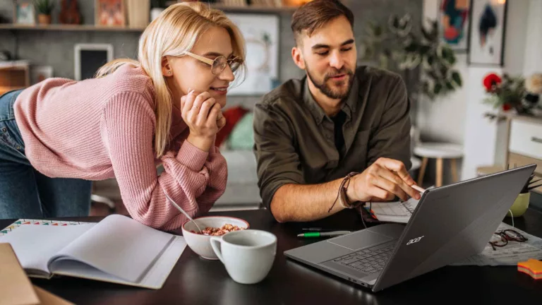 Man and woman looking at Chromebook Plus laptop
