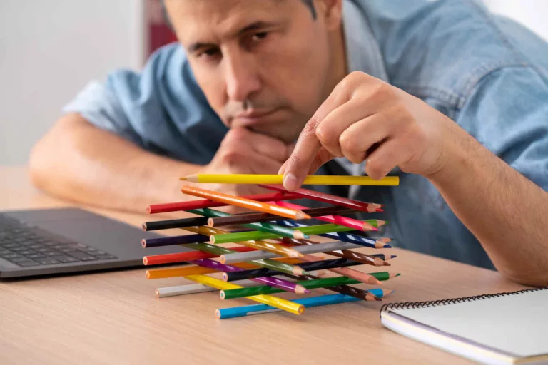 what is rust-out shown by man building a tower of coloured pencils