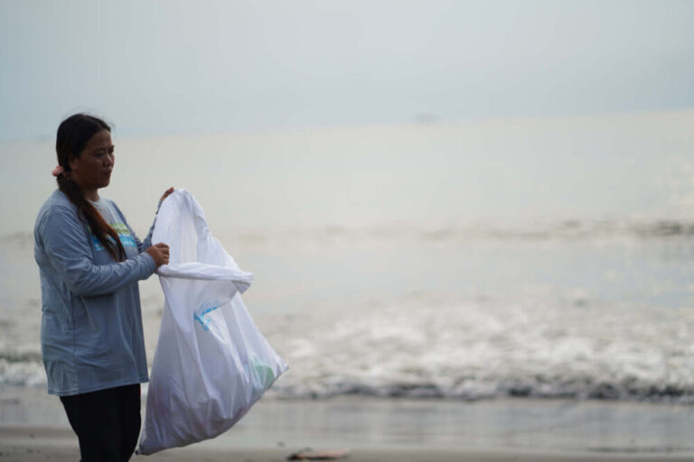 what is ocean bound plastic - woman picking plastic from beach
