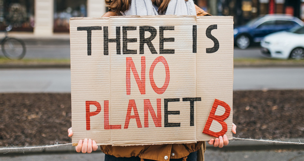 Protester with a sign that reads "There is no Planet B" at a rally against climate change. Digital Exceptionalism