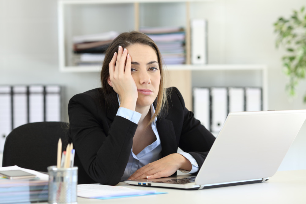 Productivity theatre shown by fed up looking employee - fake buzyness