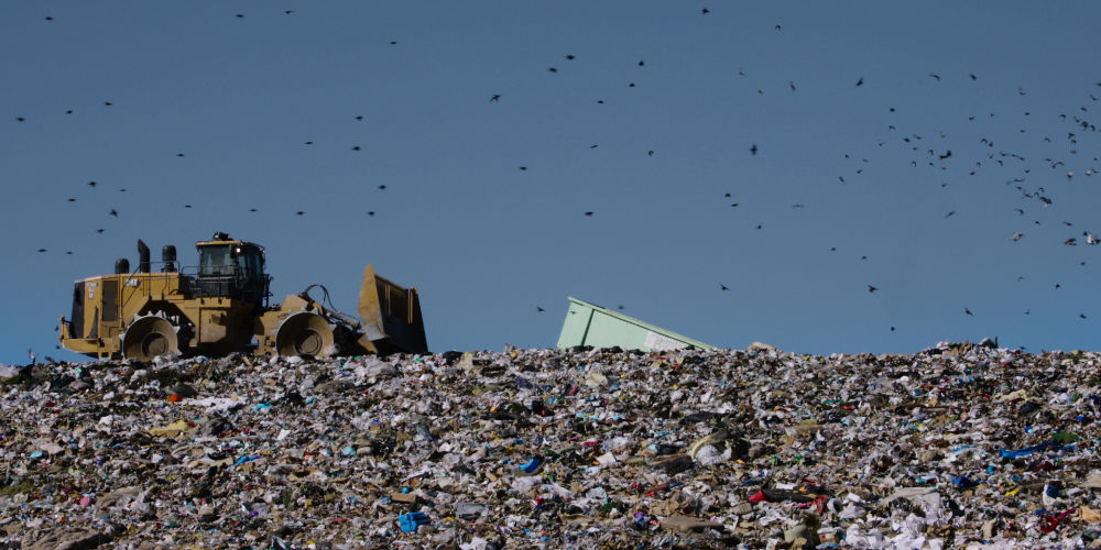 Still image from Buy Now The Shopping Conspiracy, trash bulldozers. - Interview with Kyle Wiens iFixit