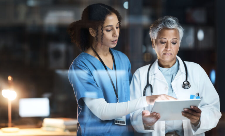 IT Healthcare shown by doctor and nurse looking at tablet