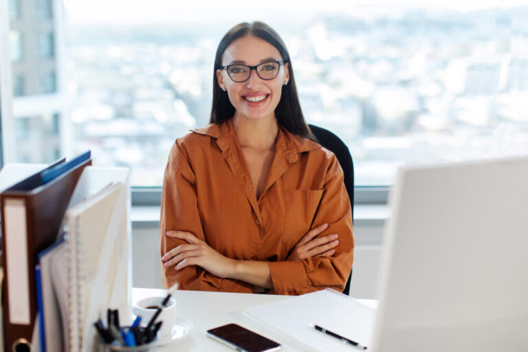 dell business productivity shown by cheerful office worker sitting at workplace and smiling at camera