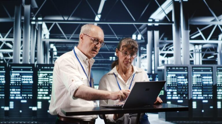 HPE private cloud shown by two IT team members checking laptop in server room