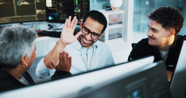 reduce IT teams burden image - high fiving trio in front of a computer screen