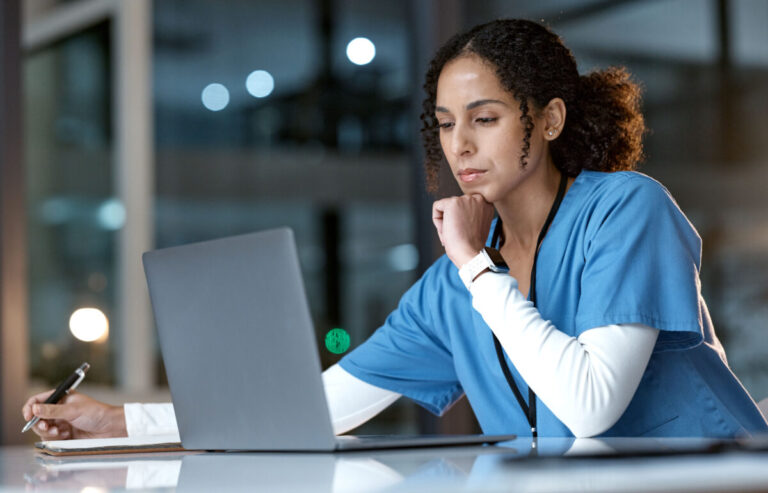 Oracle electronic health records: Doctor, thinking and writing with laptop at night for healthcare solution, idea or planning at hospital. Woman medical nurse working late in focus for research with notebook and computer at clinic