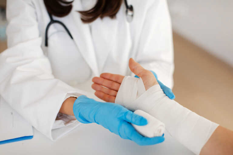 oracle health partnership shown by nurse bandaging a patient's hand