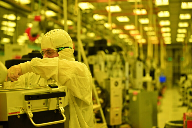 An engineer at work inside the yellow-lit Fab 52 (image: Intel)