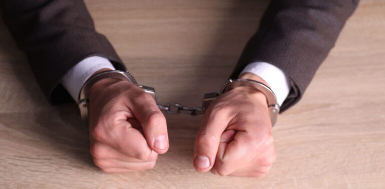 Altia FIT shown by Man in handcuffs at wooden desk, closeup