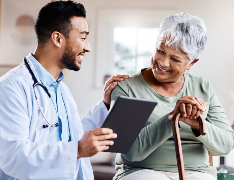 Oracle healthcare deals shown by shot of a young doctor sharing information from his digital tablet with an older patient.