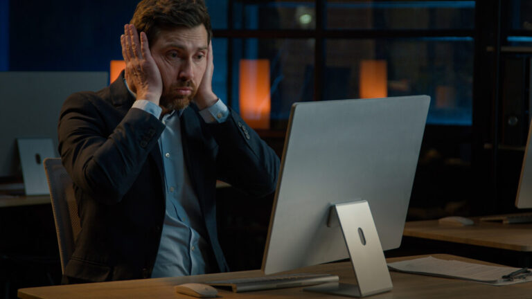 IAM fails shown by frustrated stressed businessman at work in an office in the evening