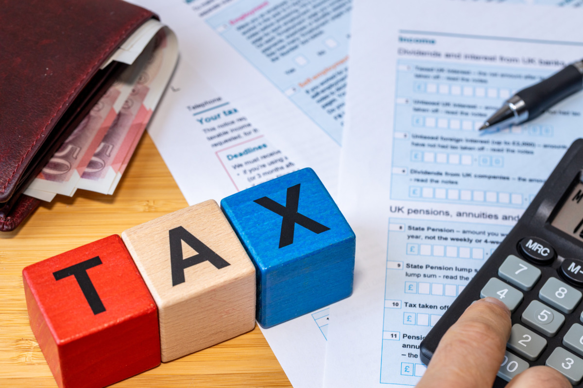 UK Income Tax Return. Financial and business Concept. United Kingdom National Colors and the word TAX. Tax Form, Money, and Calculator. Close up. Flat lay