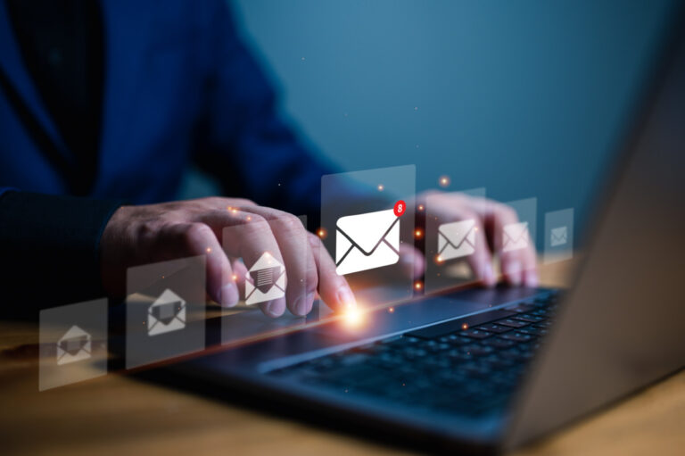 Mimecast API Email illustrated by man using laptop with emails popping up virtually before him