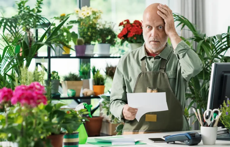 accounting mistakes illustrated by photo of a shocked flower shop owner with a bill in his hands