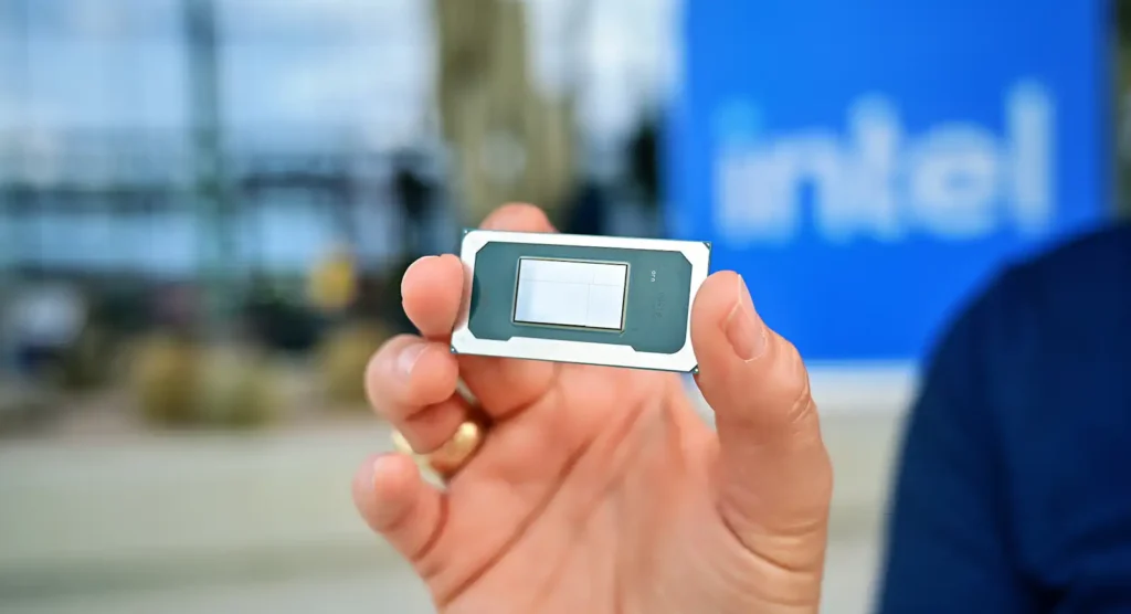 An Intel Core Series 3 Ultra chip held by an Intel employee