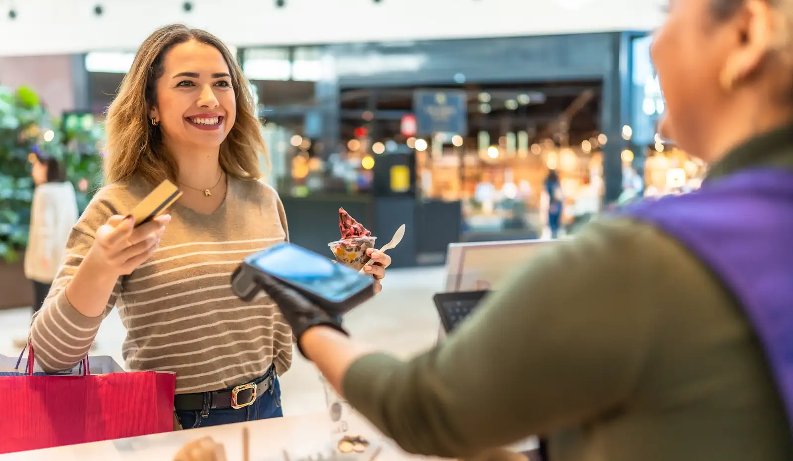 Woman making contactless credit card payment for ice cream